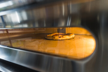 shot of pizza baking in an electric oven, restaurant concept, italian cuisine. High quality photo