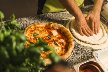 Man working in restaurant kitchen preparing traditional pizza. High quality photo