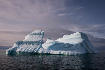 majestic iceberg with many textures with cloudy skies, greenland in the arctic