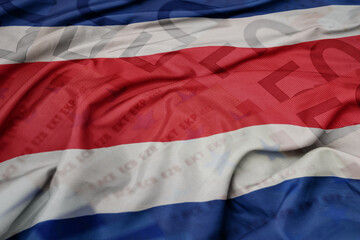 waving colorful national flag of costa rica on a euro money banknotes background. finance concept.