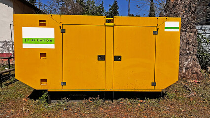 Yellow coloured industrial generator placed in the field.