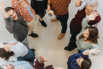 Top view of a smiling, diverse group of men and women joining hands in a circle, showcasing unity...