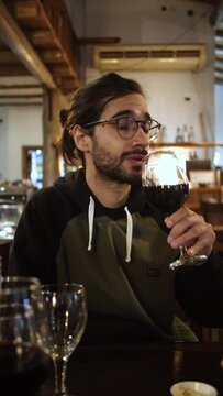 Young Man Savoring Wine Aroma with Pretentiousness in Restaurant - Sophisticated Dining Experience Concept
