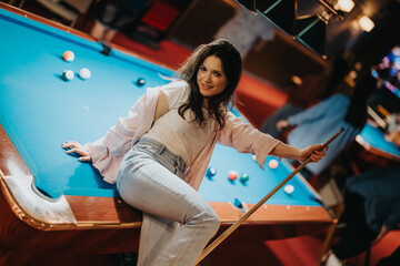 A joyful young woman plays pool at a vibrant bar, reflecting a night out filled with fun and games...