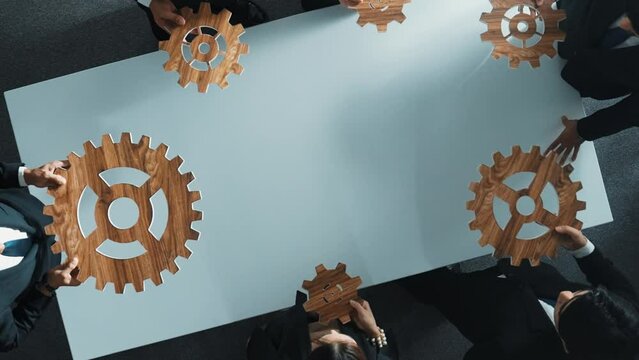 Top view of smart business people gather wooden cog together at meeting. Group of project manager helping and team working to solve problem at meeting room or workplace. Represent unity. Directorate.