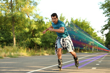 Young man roller skating outdoors. Light trails showing his speed