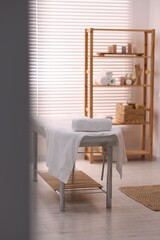 Comfortable massage table with clean towels in spa center