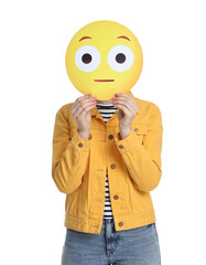 Woman covering face with surprised emoticon on white background