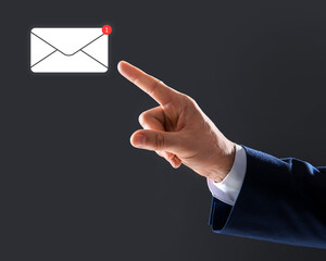 Email. Man touching virtual screen with incoming letter notification against dark background,...
