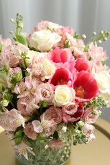 Beautiful bouquet of fresh flowers on coffee table in room