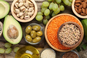 Different products high in natural fats on wooden table, flat lay