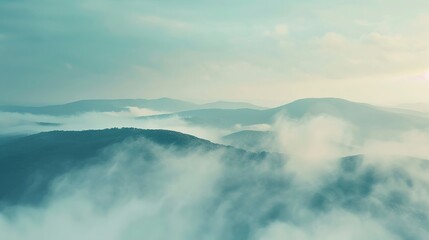 Naklejka premium Misty horizons on a mountain top, the early morning fog softening the view, mysterious and inviting
