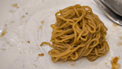 Stir-fried noodles with black sauce on a white plate
