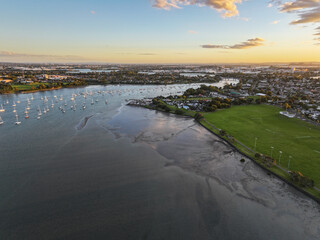 Widefield view of boats on the Tamaki river at sunset in Auckland, NZ