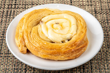 A cream cheese filled Danish pastry on a wooden table