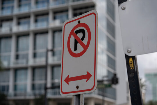 no parking sign in red and white in a downtown urban city