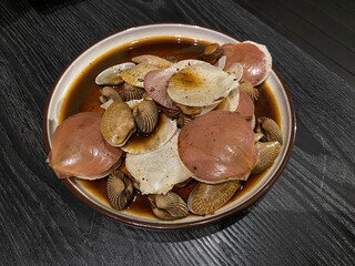 Scallop and blood cockles, cooked with soy sauce, on black table