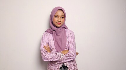 Indonesian teenage girls dressed in kebaya and hijab look forward and smile