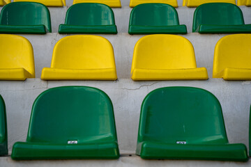 Empty green and yellow seats in the stadium.