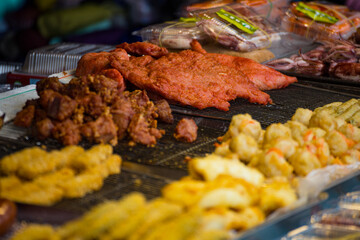 a variety of delicious fried foods displayed in metallic bowls at a street food stall