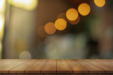 Empty wooden table top with lights bokeh on blur restaurant background.