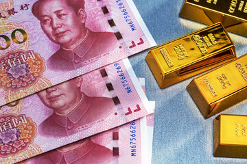 Top view of gold bars​ and yuan banknotes. Business finance concept.