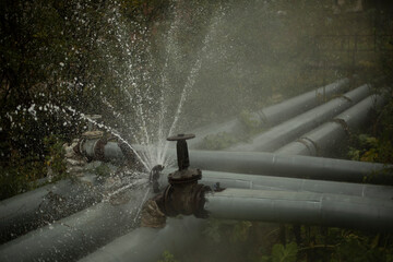 Water pouring out of broken pipe. Pipeline breakthrough. Boiler station accident.