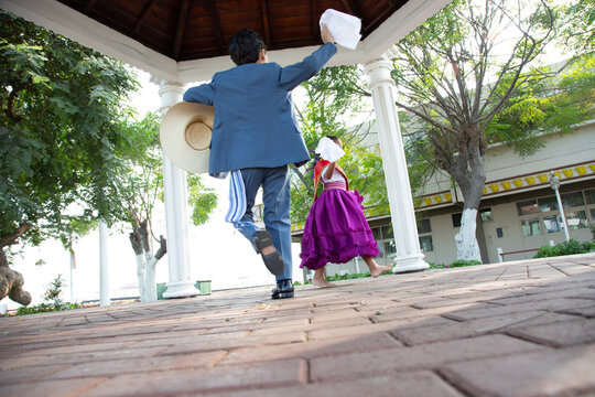 Couple of young kids dancing marinera peruvian traditional dance 