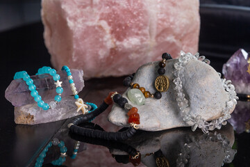 Quartz bracelets with amulets and pendants on rocks.