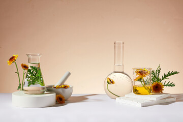 Front view of some types of glassware filled with liquid of Calendula flower extract displayed on...