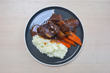 Braised beef ribs with carrot and mash potato.