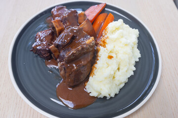 Braised beef ribs with carrot and mash potato.