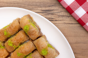 Baklava on plate, Turkish Baklava with pistachio on plate,  dessert on white plate with red and white checkered cover,  top view, background.