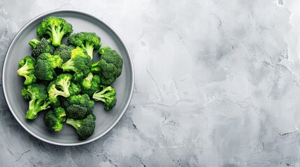 Fresh green broccoli on a plate with copy space on a gray background