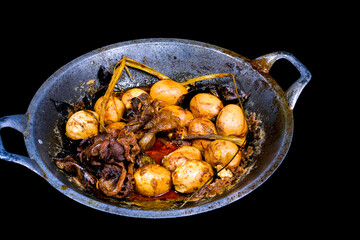 Close-up view of chicken eggs boiled with selected spices, isolated in a frying pan.