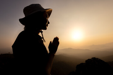 Silhouette of Person women  demonstrating their religious faith. women hand in prayer, expressing his religious faith in God through worship of Jesus Christ.turned to God in prayer.