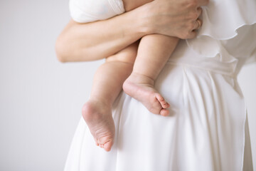 Mother holding her baby on white background, close-up shot.