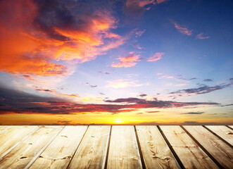 Fototapeta na wymiar Wooden table on sky background and sunset light