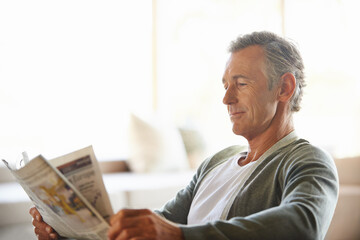 Mature, man and newspaper for reading in home, relax and information or articles in morning with...