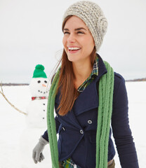 Woman, snowman and smile in nature on holiday with thinking, clothes and adventure in cold. Person,...