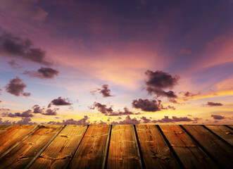 Wooden table on sky background and sunset light