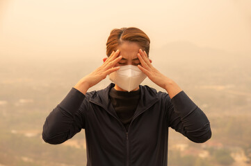 Asian woman having headache becaused of by Bad air pollution (PM2.5). 