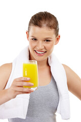 Portrait, girl and studio with orange juice, glass and healthy for exercise, towel and vitamin c on white background, isolated and wellness. Drink, vitality and cheerful in sports, nutrition and diet