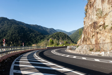Turning asphalt road with new marking lines with mountains in Vietnam.