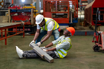 African American factory worker having accident while working in manufacturing site while his...