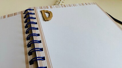 Notebook, diary, paper, pencil, brown, black and white on the table.