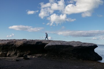 Man walking on giant reef rock at low tide in Musick Point. Bucklands Beach, Auckland, Auckland,...