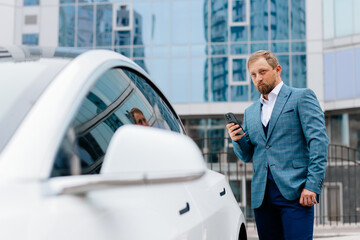 A successful businessman near a business class car. Future clean energy solution for automotive...