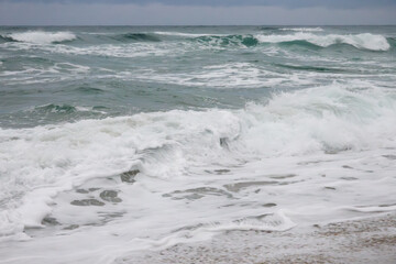 View of the surf on the snowing sand beach