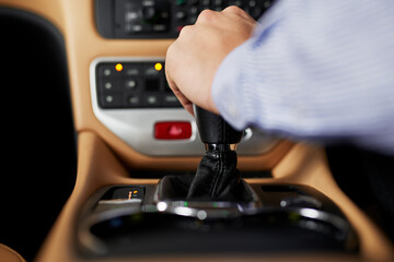 Hands, center console and gear of car for shift, transmission and speed change for driving or...